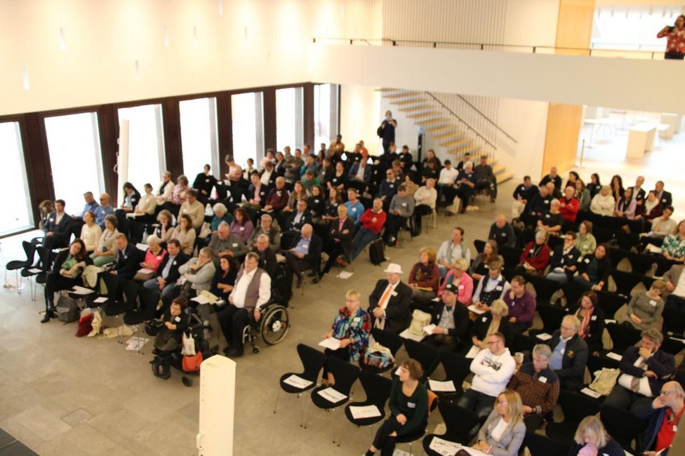 Das Foto zeigt das Plenum des 11. Hessischen Tages der Menschen mit Behinderungen in der Hessischen Staatskanzlei in Wiesbaden