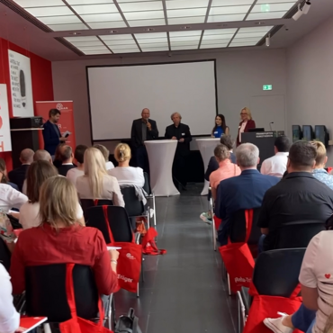 Blick von hinten auf das Plenum und das Podium bei der Netzwekveranstaltung in Frankfurt am Main.