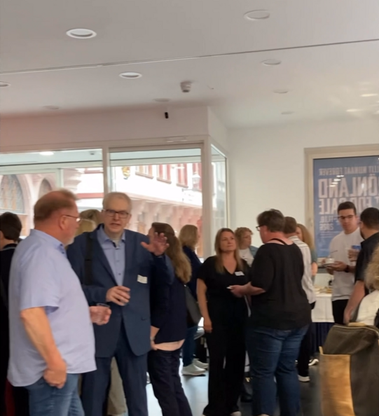 Das Foto zeigt Reha-Fachkräfte aus Hessen im Foyer des Frankfurter Kunstvereins, die sich unterhalten..