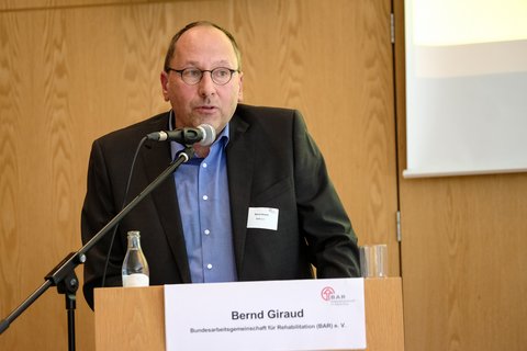 Bernd Giraud von der BAR spricht am Rednerpult zu den Teilnehmenden.